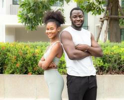 glimlachen jong stel, Mens en vrolijk vrouw gelukkig ontspannende samen buitenshuis in de park. portret van romantisch Mens zorgeloos dating afro haar- vriendin. twee mensen, man en vrouw hebben pret vrije tijd. foto