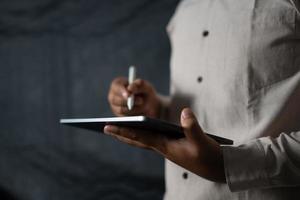 hand- Holding tablet en pen naar toezicht houden op bedrijf foto
