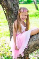 gelukkig weinig aanbiddelijk meisje in bloeiende appel tuin foto