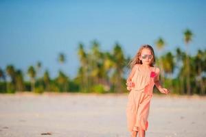 aanbiddelijk weinig meisje Bij tropisch strand gedurende vakantie foto