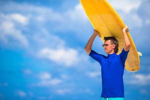 gelukkig jong Mens surfing Aan de tropisch kust foto