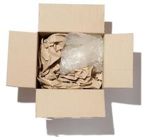 Open karton doos, binnen verfrommeld papier en polyethyleen foto