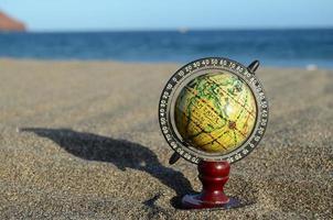 wereldbol in de zand foto