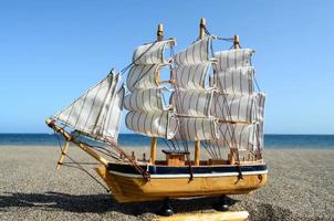 het zeilen schip model- Aan de strand foto