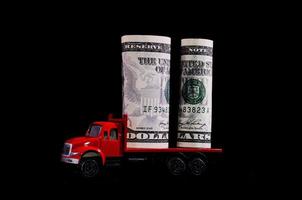 speelgoed- vrachtauto draag- contant geld Aan zwart achtergrond foto