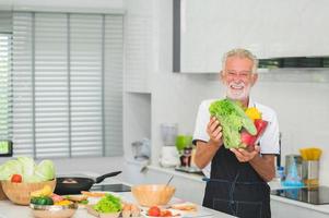 gelukkig senior Mens in keuken foto