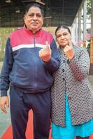 nieuw Delhi, Indië - december 04 2022 - niet geïdentificeerd mensen tonen hun met inkt gemarkeerd vingers na gieten stemmen in voorkant van peiling stand van oosten- Delhi Oppervlakte voor mcd lokaal lichaam verkiezingen 2022 foto