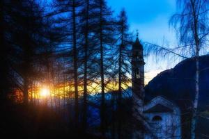 berg kerk Bij zonsondergang foto