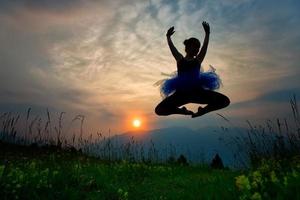 meisje danser in natuur Bij de zonsondergang foto