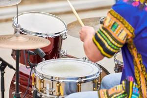 drummer man drummen percussie met stokken, drumstel op concertpodium, drumsticks en drums foto