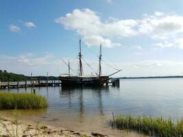 oud boot aangemeerd Aan rivier- of meer water foto