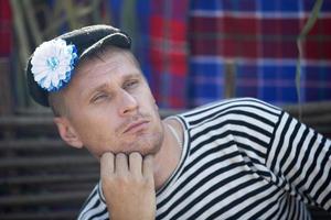 Wit-Rusland, aftyuki dorp, juli 31, 2022. vakantie van humor. grappig Mens in een hesje en een hoed versierd met een bloem. foto