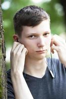 Wit-Rusland, stad van gomil, juni 20, 2019. straat in de stad. een jong Mens in hoofdtelefoons looks Bij de camera. foto