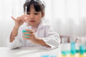 opleiding, wetenschap, chemie en kinderen concept - kinderen of studenten met test buis maken experiment Bij school- laboratorium foto