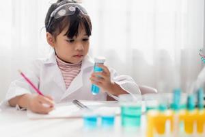 opleiding, wetenschap, chemie en kinderen concept - kinderen of studenten met test buis maken experiment Bij school- laboratorium foto