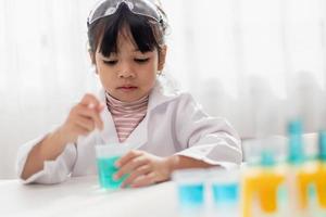 opleiding, wetenschap, chemie en kinderen concept - kinderen of studenten met test buis maken experiment Bij school- laboratorium foto