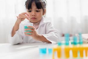 opleiding, wetenschap, chemie en kinderen concept - kinderen of studenten met test buis maken experiment Bij school- laboratorium foto