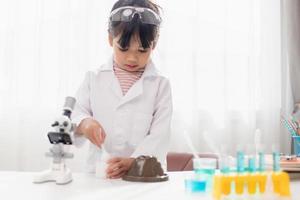 opleiding, wetenschap, chemie en kinderen concept - kinderen of studenten met test buis maken experiment Bij school- laboratorium foto