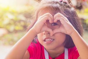 Aziatisch kind maken handen gebaar in de hart vorm van liefde. voor Valentijnsdag dag gevierd concept. foto