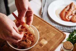 vrouw schoonmaak garnalen voor Koken. werkwijze van handen Pel garnalen schelp foto