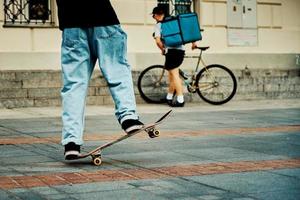 skateboarder rijden Aan skateboard Bij stad straat, dichtbij omhoog foto