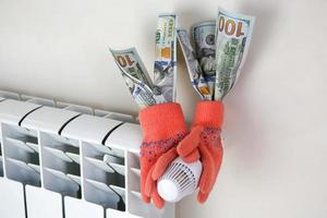 radiator, warm handschoenen en dollar. de concept van betaling voor verwarming. foto