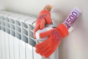 radiator, warm handschoenen en geld. de concept van betaling voor verwarming. foto