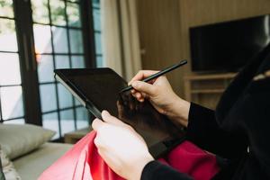 volwassen zakenman gebruik makend van een digitaal tablet naar bespreken informatie met een jonger collega in een modern bedrijf lounge foto