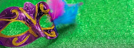 Purper carnaval masker Aan groen glimmend achtergrond. mardi gras of dik dinsdag symbool. foto