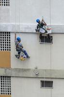 rio, Brazilië, november 04, 2022, pater werken Aan woon- gebouw facade herstel door touw net zo een klimmer foto