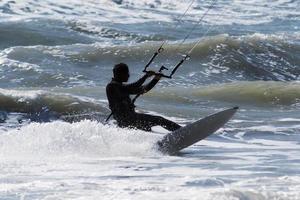 silhouet van vlieger surfer jumping over- de golven foto