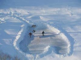 het schaatsen baan Aan de rivier- in winter, kinderen ijs het schaatsen, antenne visie foto