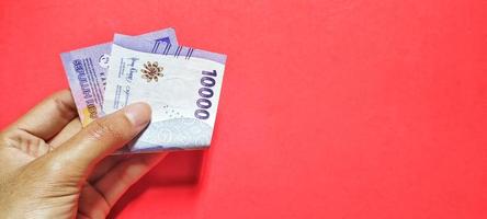 Mens Holding Indonesisch laatste editie van 10.000 roepia bankbiljetten foto