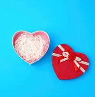Open rood hartvormig geschenk doos met een boog Aan een blauw achtergrond foto