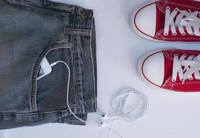 blauw jeans met mobiel telefoon in de zak- in de buurt jeugd rood schoenen foto
