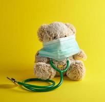 grijs teddy beer en groen medisch stethoscoop foto