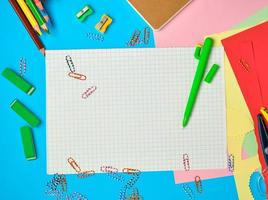wit in het kwadraat papier van notitieboekjes, houten gekleurde potloden, papier clips foto