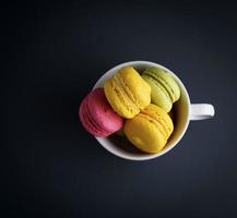 cakes van amandel meel macarons in een wit keramisch kop foto