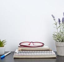 stack van spiraal notebooks De volgende naar een keramisch pot met een bloem Aan een zwart tafel foto