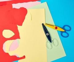 paar- van plastic schaar en gekleurde papier voor snijdend figuren foto