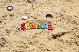 opschrift zomer Aan zand met schelpen foto