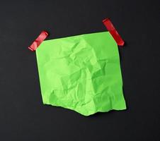 groen verfrommeld vel van papier gelijmd met rubber rood Zelfklevend plakband foto