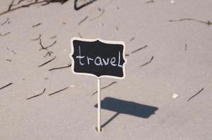 zwart houten bord met opschrift reizen Aan de kust foto