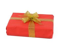 rechthoekig doos verpakt in rood papier en gebonden met een gouden lint Aan een wit achtergrond foto