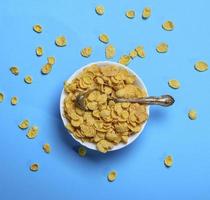 cornflakes in een wit keramisch bord en een ijzer lepel foto