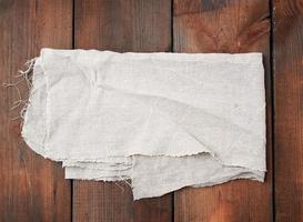 gevouwen grijs linnen handdoek Aan houten achtergrond, top visie foto