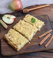 plakjes van appel crumble taart Aan bruin houten bord foto