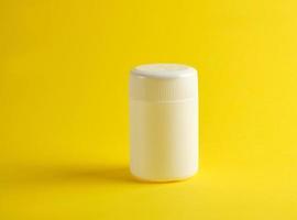 Gesloten wit plastic pot voor geneesmiddelen Aan een geel achtergrond foto