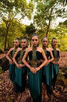 aantrekkingskracht Aziatisch Dames met groen kostuums en bedenken lijn omhoog samen in de oerwoud met bruin bladeren Aan de grond foto