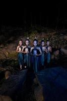 een groep van Javaans Dames staand in de bossen tussen de rotsen terwijl Holding een houten masker foto